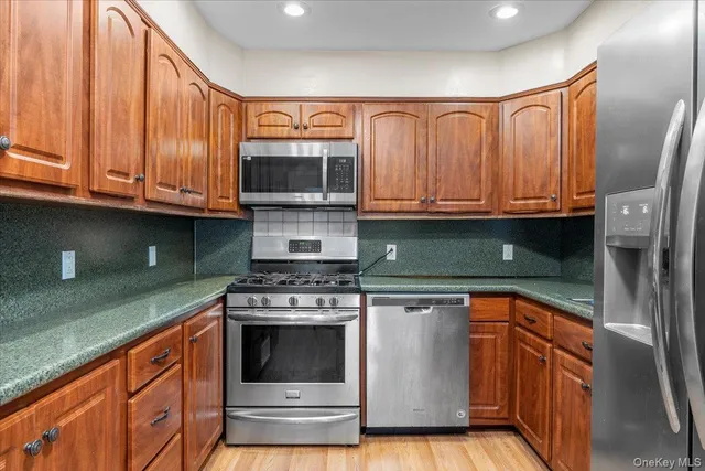 a kitchen with granite countertop a stove top oven cabinetry a sink and a microwave