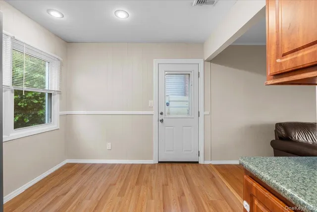 an empty room with wooden floor and window