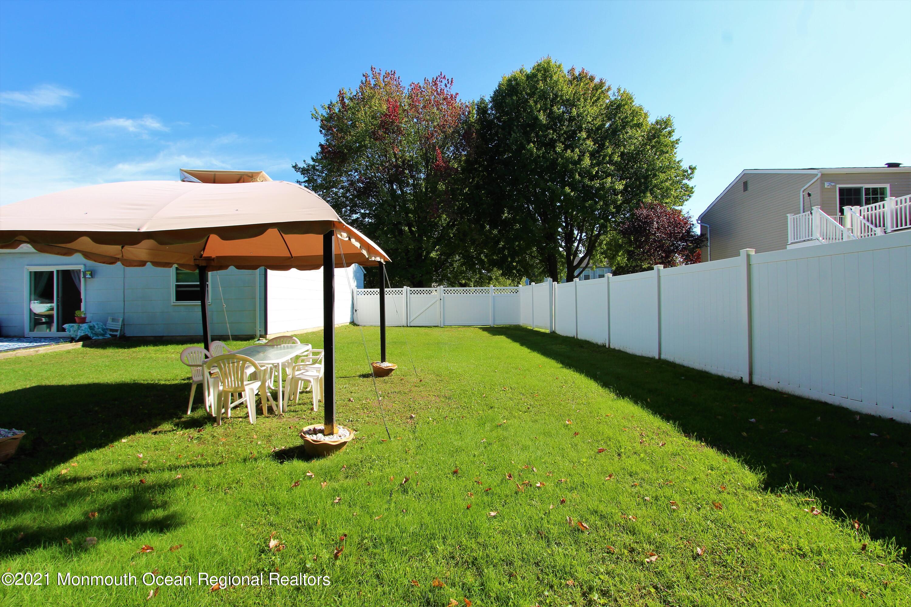 18 Rothbard Road Hazlet, NJ 07730 - Photo 7 of 23 a view of backyard with a table and chairs under an umbrella