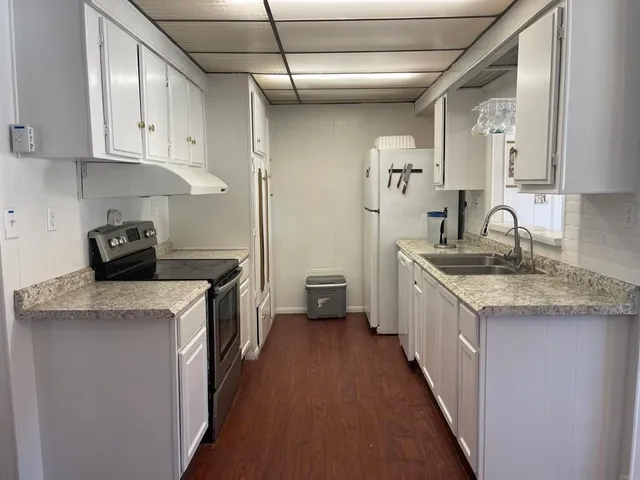 a kitchen with a sink stove and cabinets