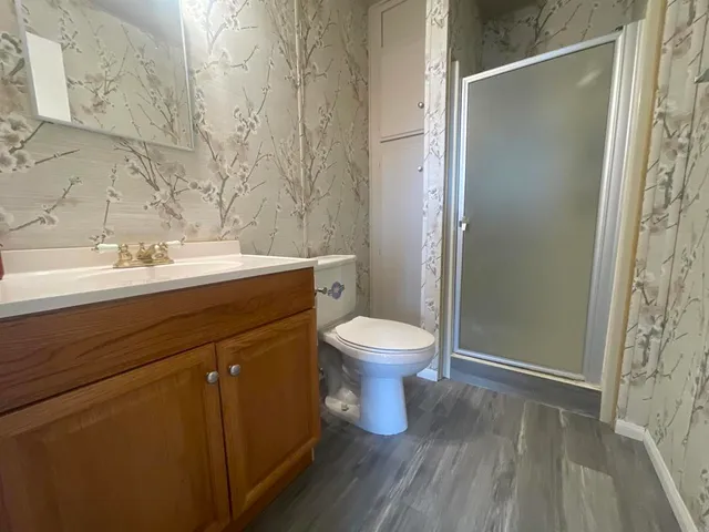 a bathroom with a sink a toilet and shower
