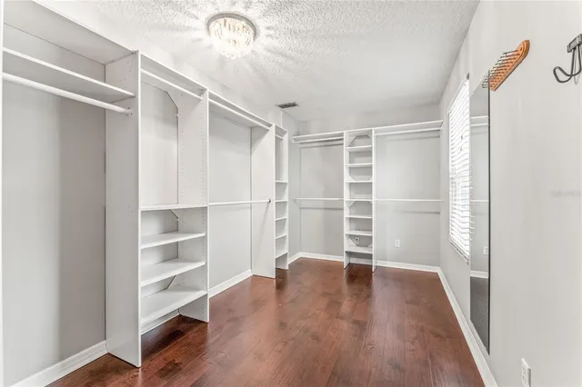 a view of walk in closet with wooden floor