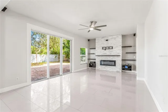 a view of an empty room with a fireplace and a window
