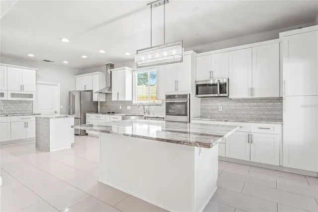 a kitchen with stainless steel appliances granite countertop a sink counter space cabinets and a large window