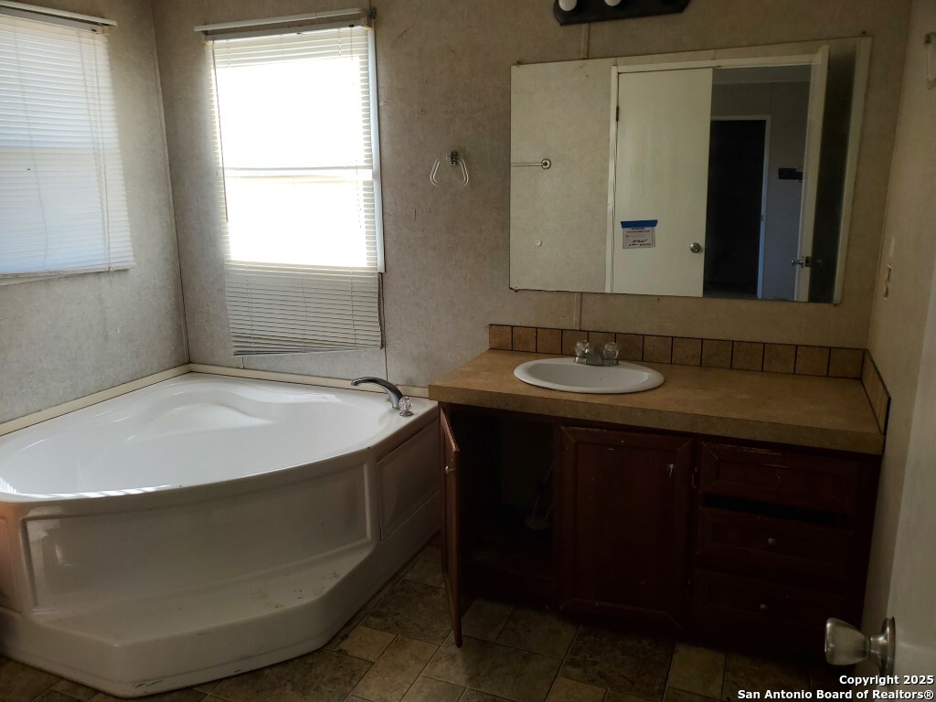 754 Kayroe Road Adkins, TX 78101 - Photo 4 of 10 a bathroom with a sink and a mirror