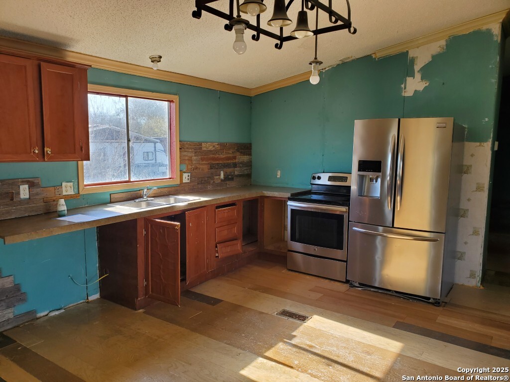 754 Kayroe Road Adkins, TX 78101 - Photo 5 of 10 a kitchen with a refrigerator and a sink