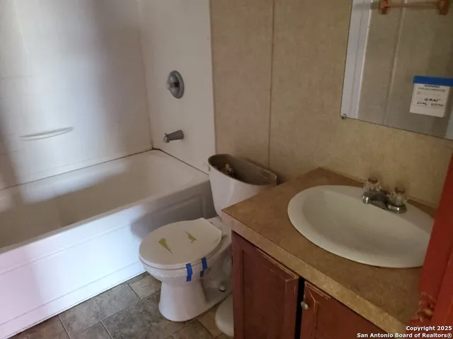 a bathroom with a sink toilet and a mirror