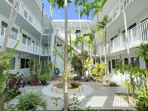 a view of a palm plant that is in front of a building