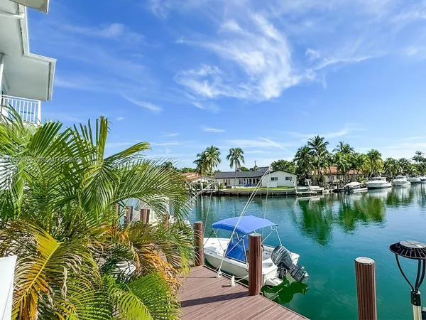 a view of a house with a big yard and large trees