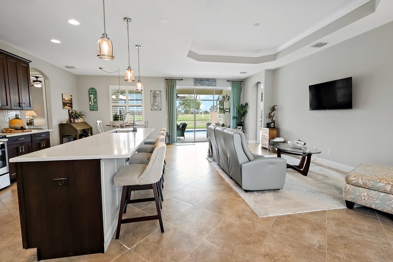 570 Gossamer Wing Way Sebastian, FL 32958 - Photo 14 of 36 a living room with furniture a flat screen tv and kitchen view