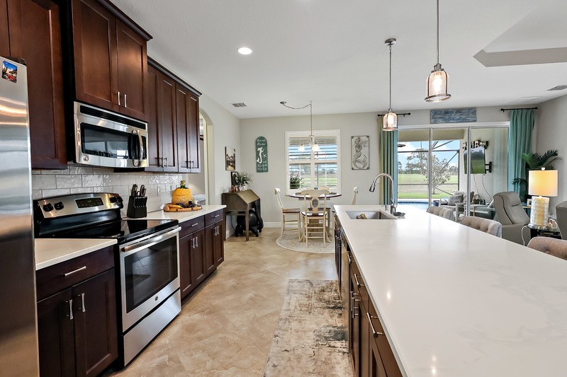 570 Gossamer Wing Way Sebastian, FL 32958 - Photo 16 of 36 a large kitchen with stainless steel appliances granite countertop a stove refrigerator and a sink