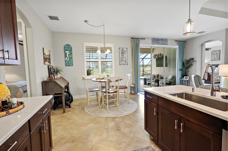 570 Gossamer Wing Way Sebastian, FL 32958 - Photo 17 of 36 a kitchen with a stove a sink a dining table and chairs