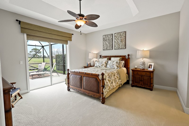 570 Gossamer Wing Way Sebastian, FL 32958 - Photo 22 of 36 a spacious bedroom with a bed and a chandelier