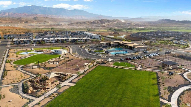 2123 Wolverine Way, Unit 2437 Washington, UT 84780 - Photo 8 of 40 Aerial perspective of a master-planned community featuring a central clubhouse, swimming pool, sports courts, and extensive green spaces