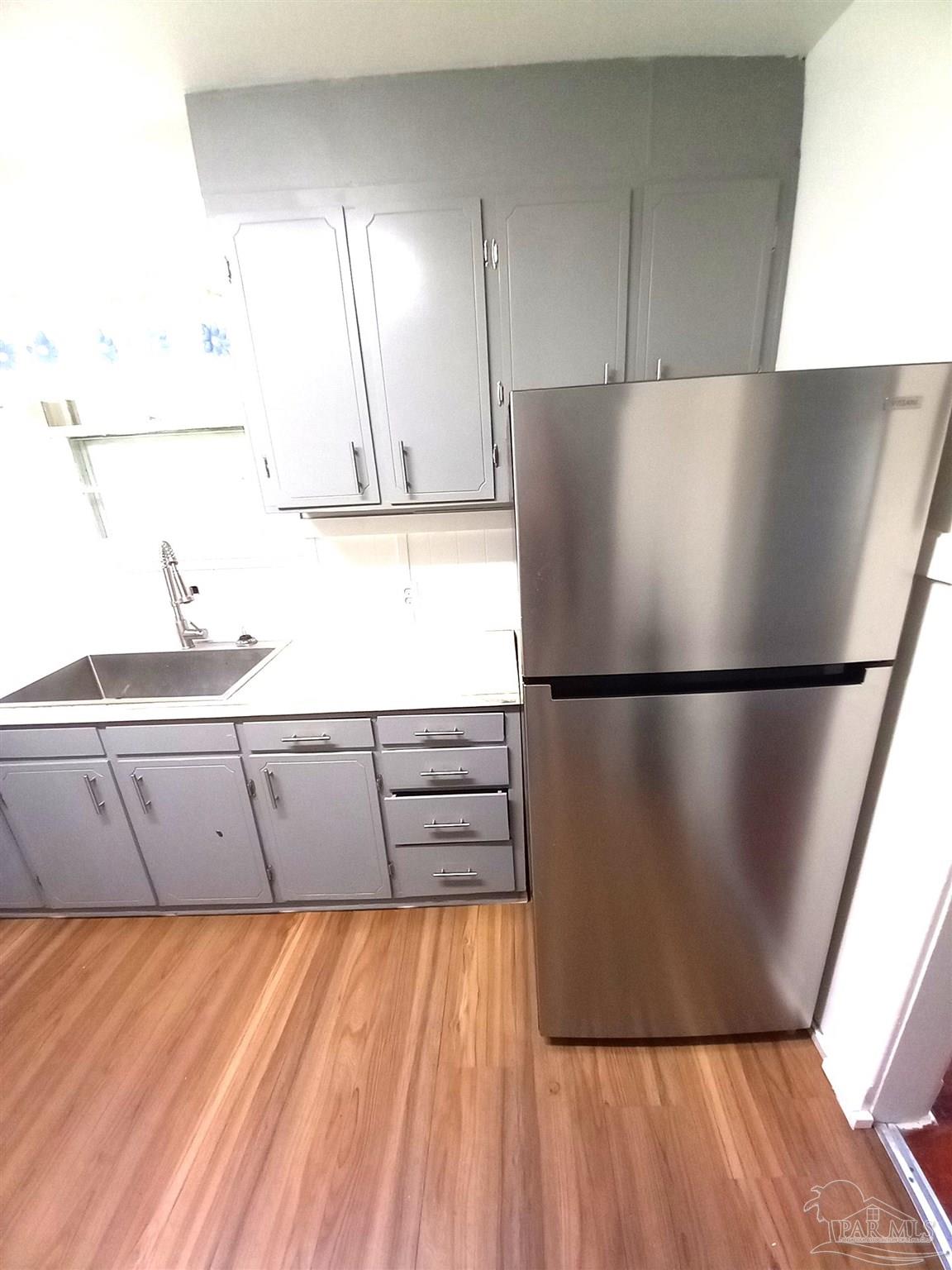 1120 South Old Corry Field Road Pensacola, FL 32507 - Photo 2 of 10 a kitchen with a refrigerator and a sink