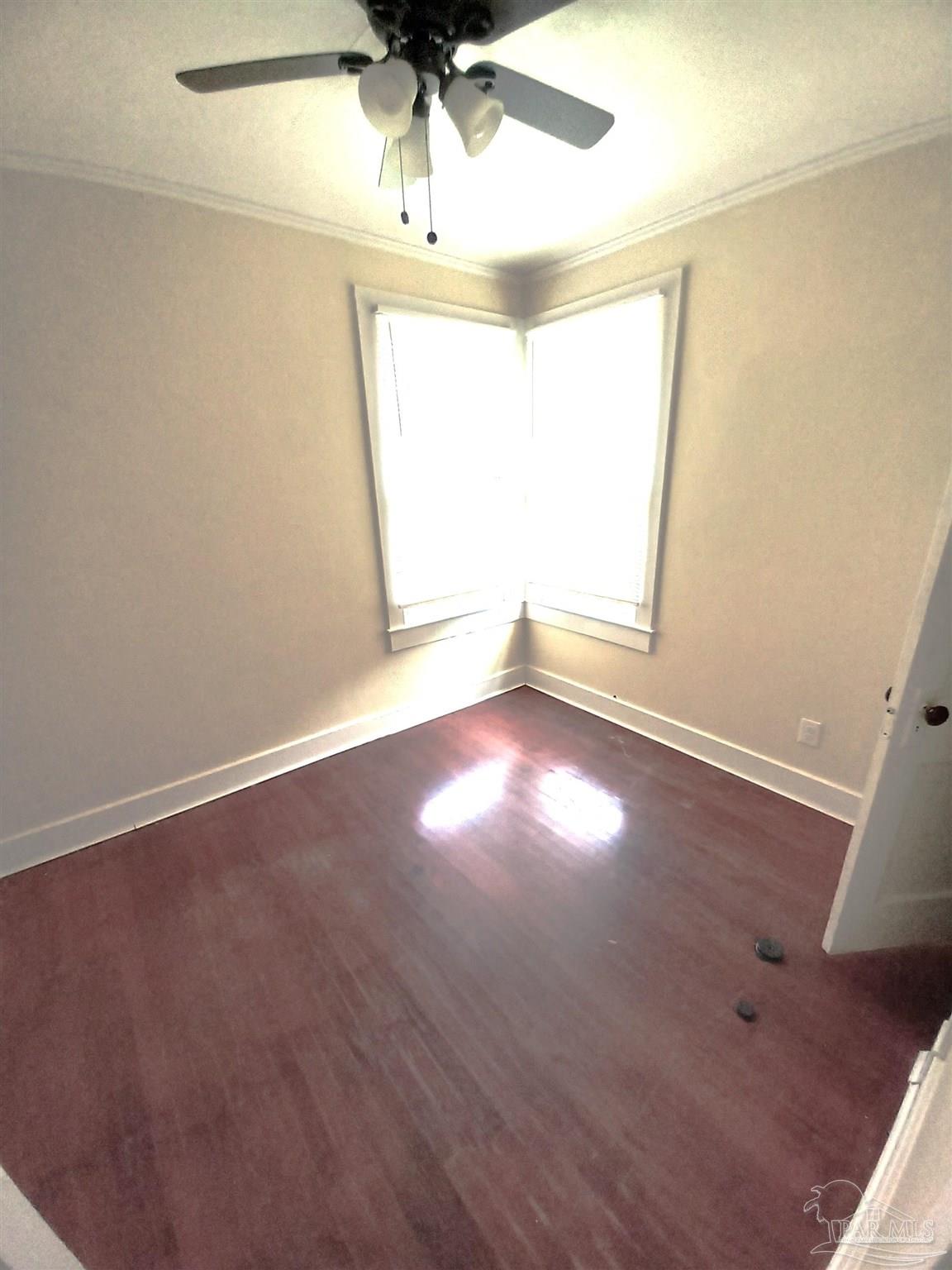 1120 South Old Corry Field Road Pensacola, FL 32507 - Photo 5 of 10 an empty room with a window and a ceiling fan