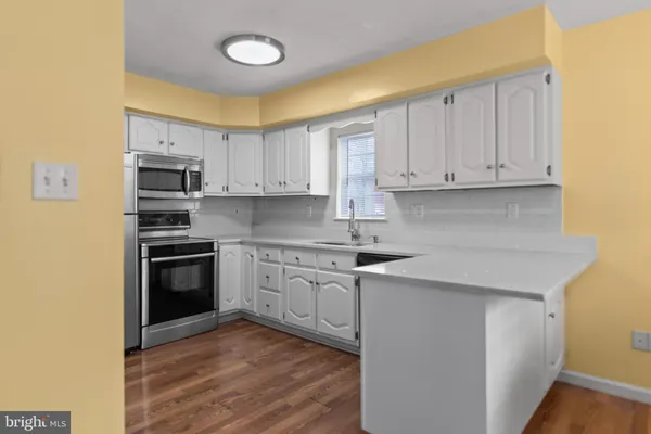 a kitchen with cabinets stainless steel appliances and a counter space