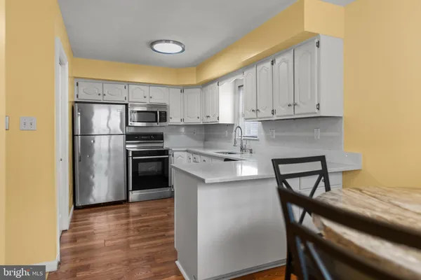 a kitchen with a refrigerator a stove top oven a sink and cabinets
