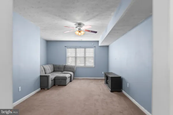 a living room with furniture and a ceiling fan