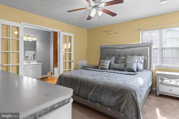 a bedroom with a bed and large windows