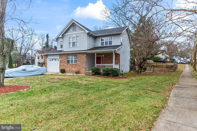 a front view of a house with a yard and trees