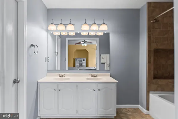 a bathroom with a double vanity sink and a mirror