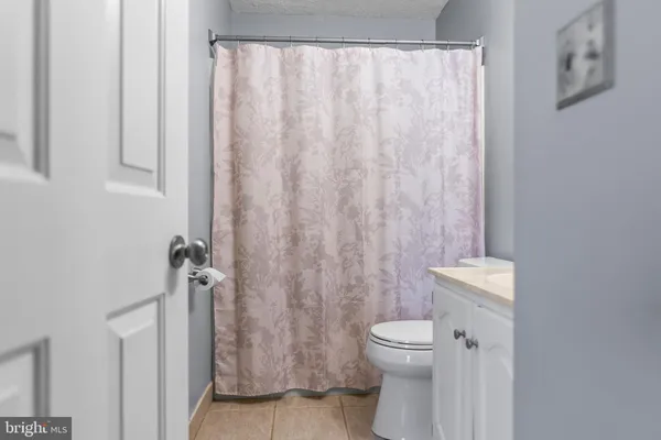 a bathroom with a toilet and a shower curtain