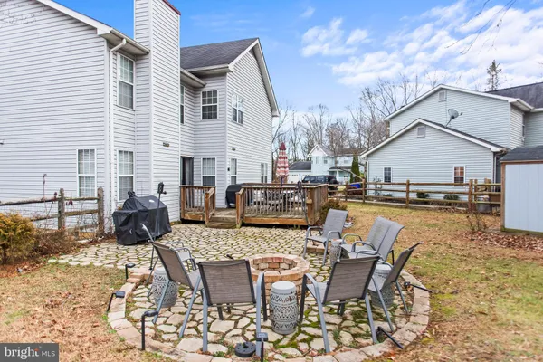 a view of a patio with table and chairs with wooden floor and fence