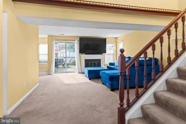 a view of an livingroom with furniture a fireplace and windows