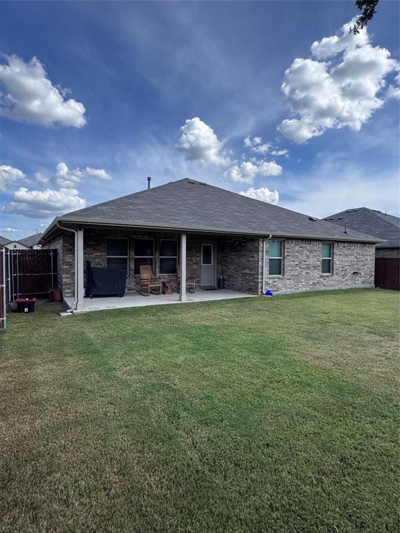 1908 Cookes Lane Cleburne, TX 76033 - Photo 14 of 17 Backyard featuring a covered patio, brick exterior, multiple windows, and a fenced perimeter