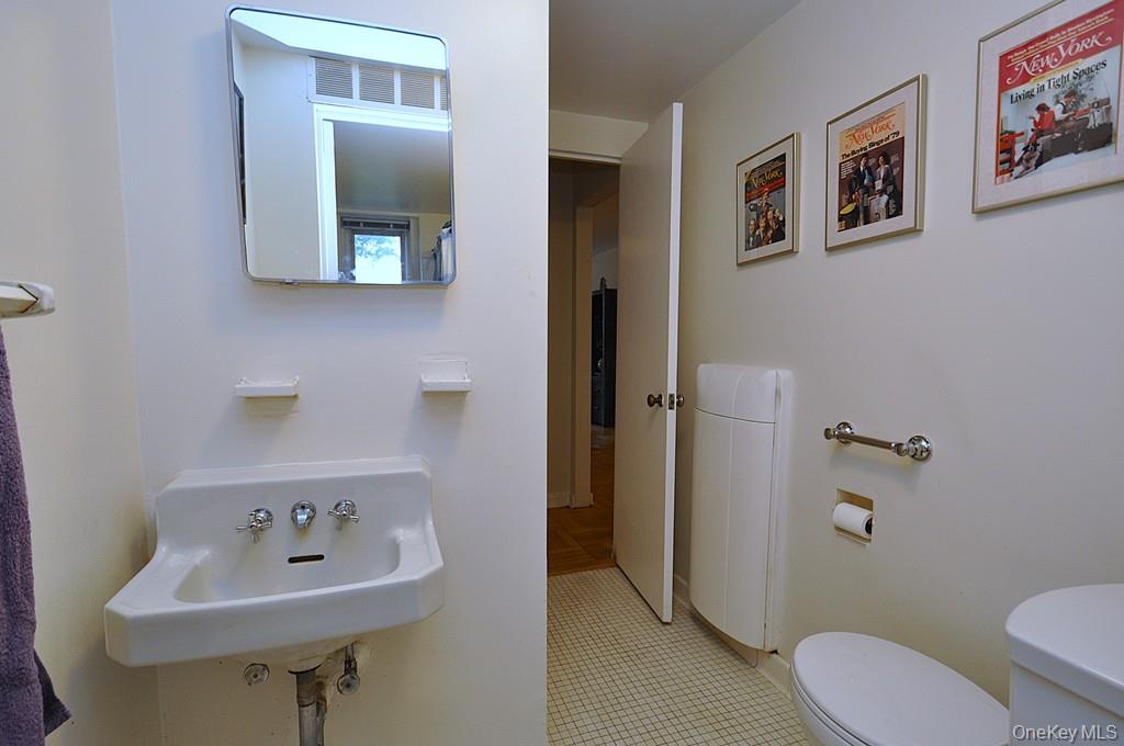 235 Garth Road, Unit A5B Scarsdale, NY 10583 - Photo 27 of 47 a bathroom with a toilet sink and mirror
