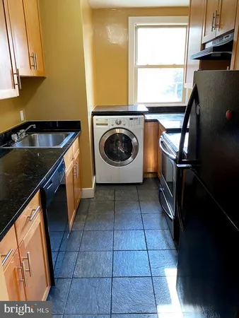 a kitchen with a sink a stove and a window