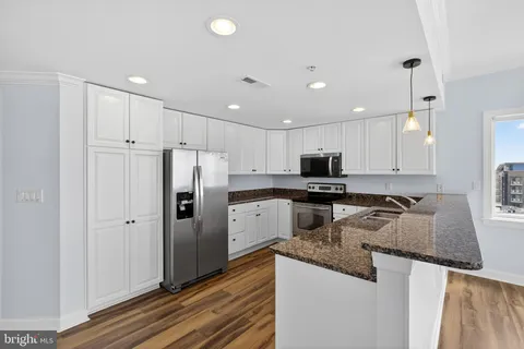 a kitchen with granite countertop a refrigerator and a sink