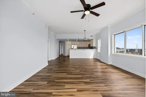 a view of a kitchen with wooden floor and a ceiling fan