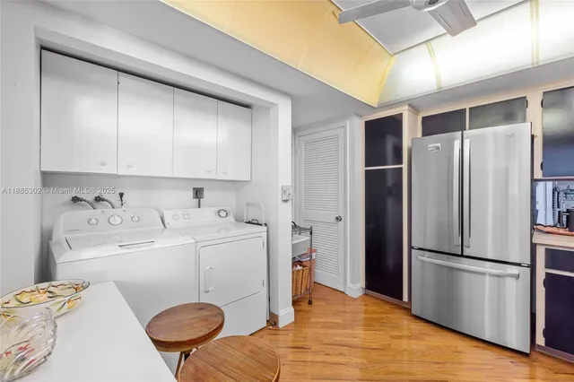 a kitchen with stainless steel appliances a refrigerator and wooden floor