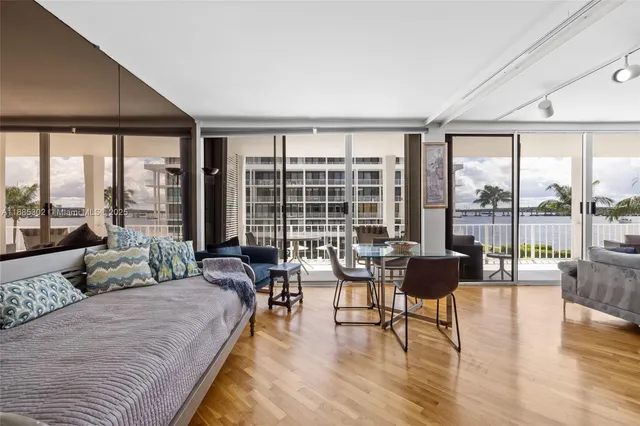 a spacious bedroom with furniture and floor to ceiling windows