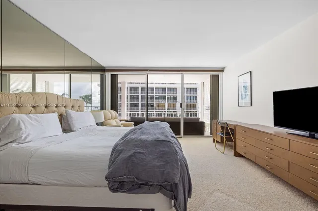 a spacious bedroom with a large bed and a flat screen television