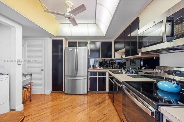 a kitchen with stainless steel appliances granite countertop a sink a stove and a refrigerator