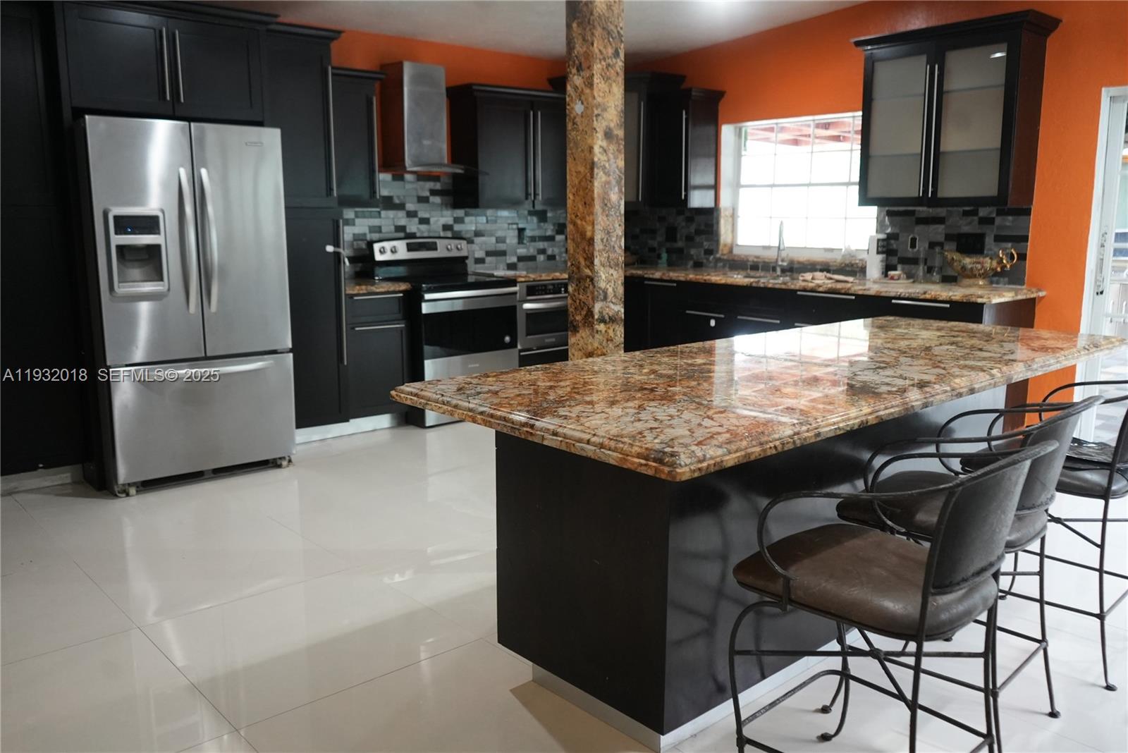 3285 Northwest 97th Street Miami, FL 33147 - Photo 6 of 44 a kitchen with granite countertop kitchen island stainless steel appliances a refrigerator a stove a sink and a refrigerator