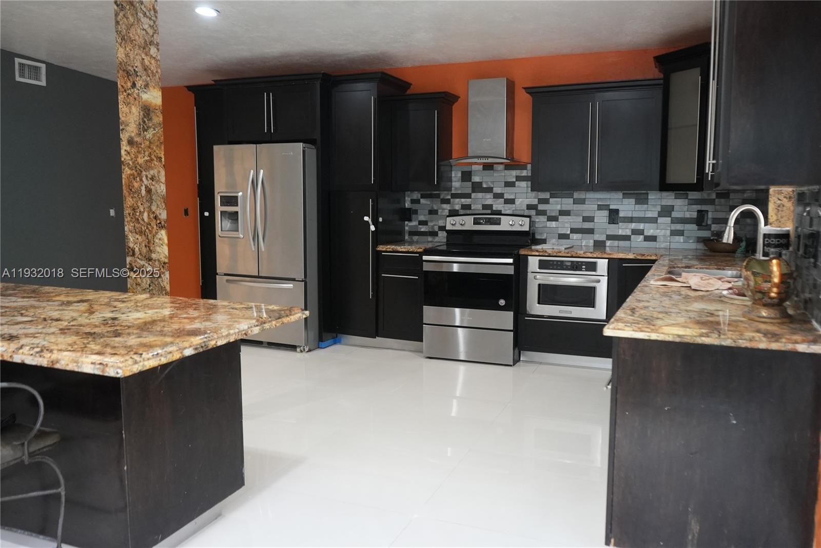 3285 Northwest 97th Street Miami, FL 33147 - Photo 7 of 44 a kitchen with stainless steel appliances granite countertop a sink stove and refrigerator