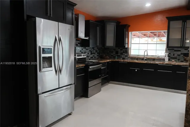 a kitchen with granite countertop a refrigerator and a sink