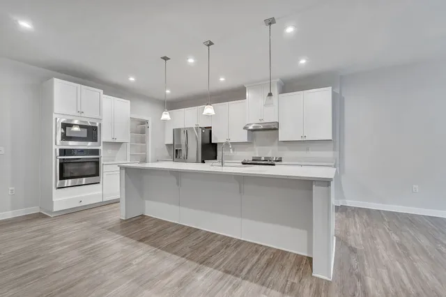 a kitchen with a sink stove and refrigerator