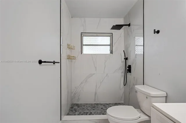 a bathroom with a toilet and a shower
