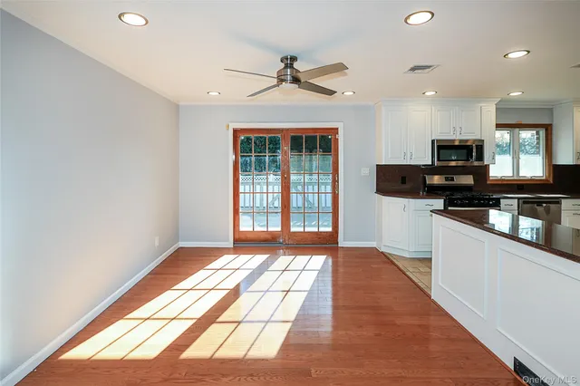 an empty room with wooden floor and a window