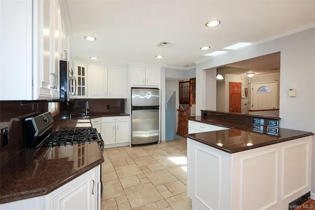 an empty room with wooden floor staircase and hallway