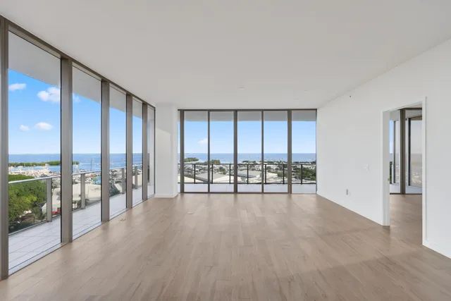 a view of an empty room with wooden floor and city view