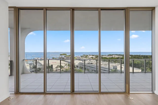 a view of empty room with wooden floor and floor to ceiling window