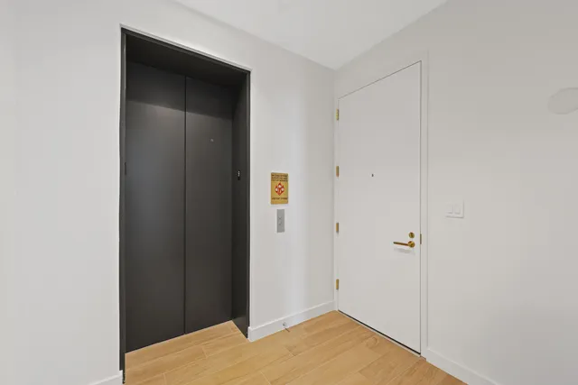 a view of a hallway with wooden floor and entryway