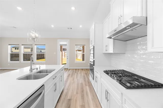 a kitchen with granite countertop a sink stove and cabinets