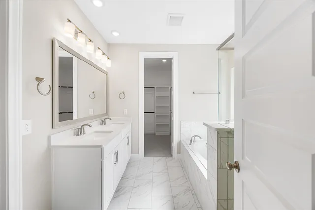 a spacious bathroom with a double vanity sink a mirror and a shower